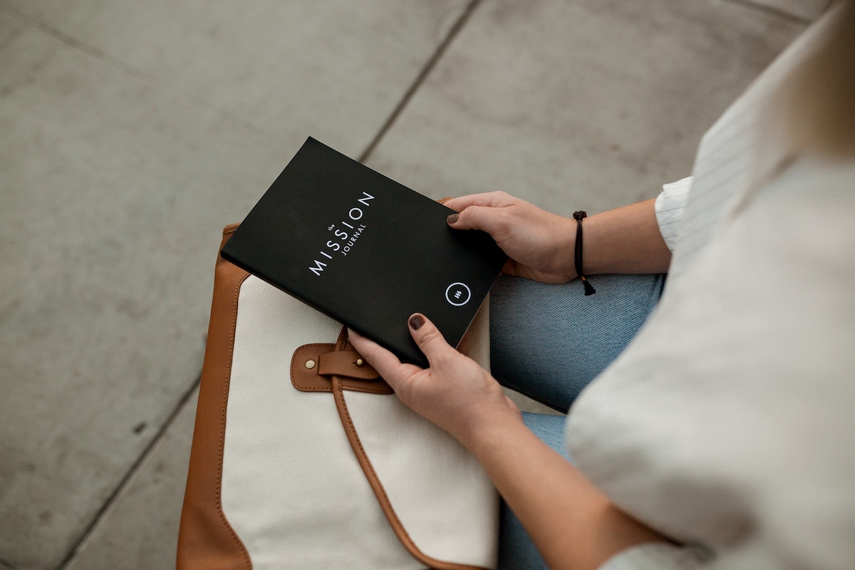 A lady looks at her notebook while sitting outside of work