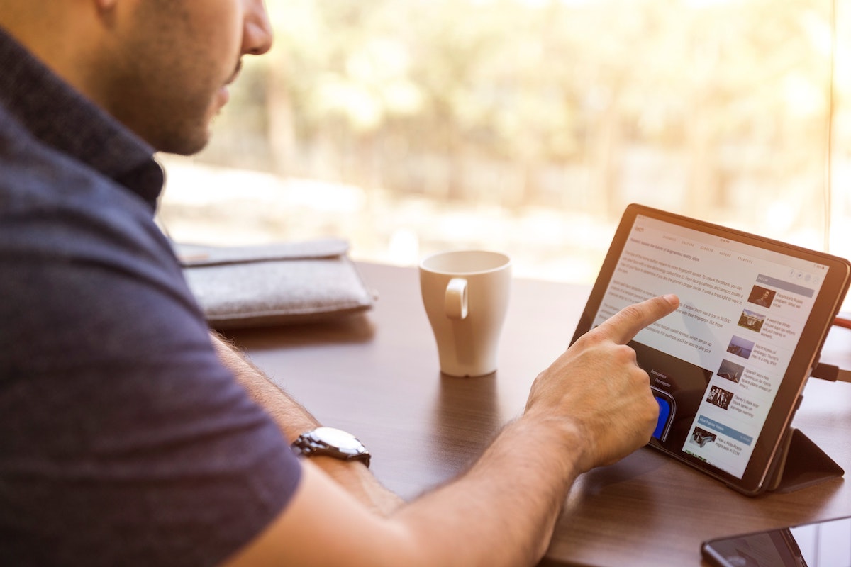 Man reading a LinkedIn message on a tablet